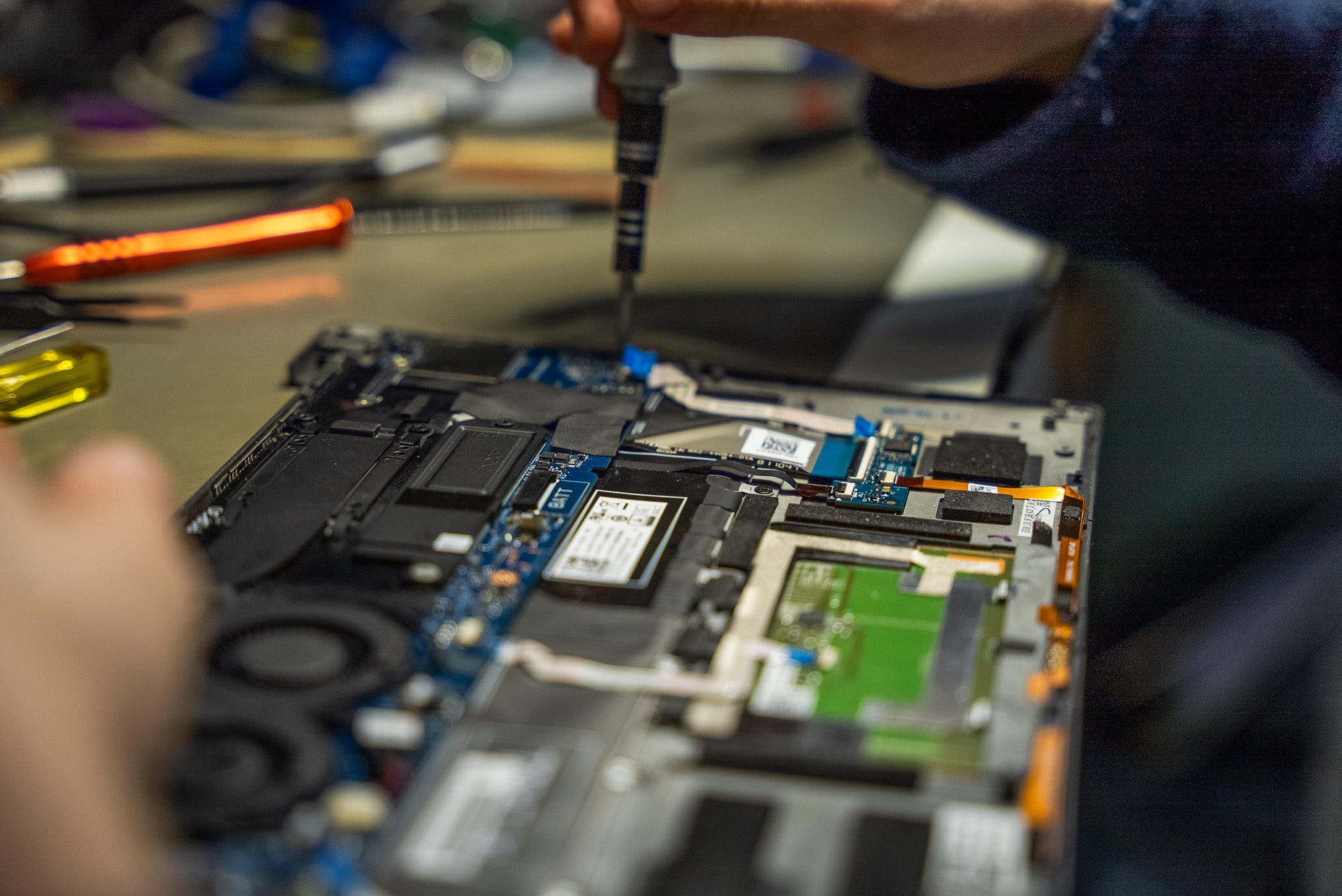 A Klyk engineer working inside an open laptop at the test bench